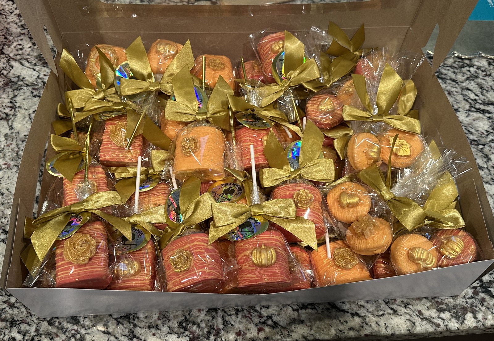 Orange, coral, and gold chocolate covered marshmallow assortment with roses, pumpkins, and satin bows