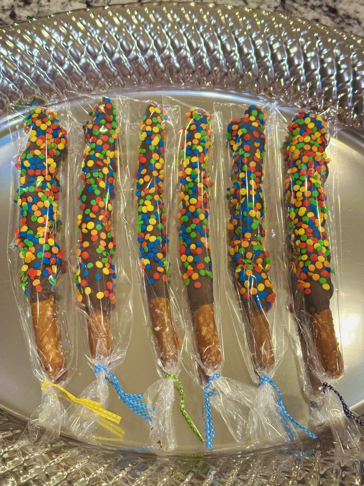 Chocolate covered pretzel rods with colorful confetti sprinkles
