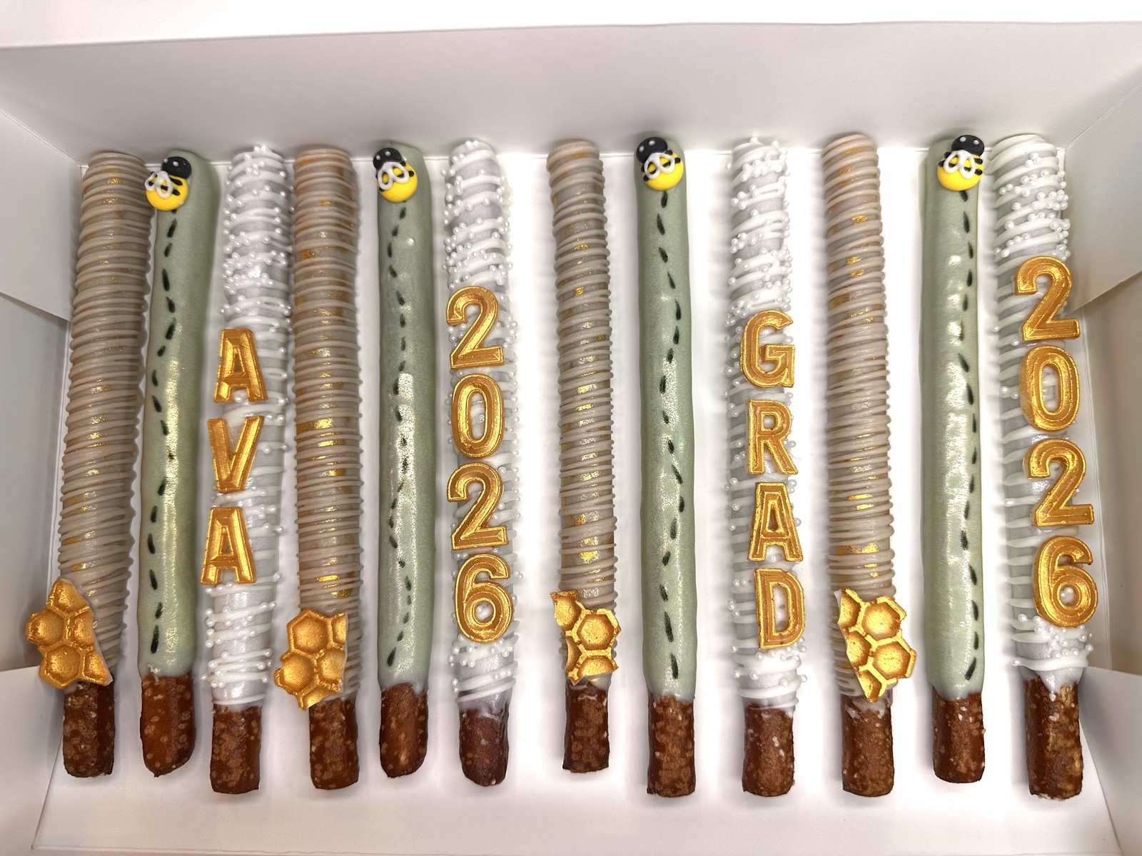 Sage, ivory, and gold graduation chocolate covered pretzels with personalized lettering