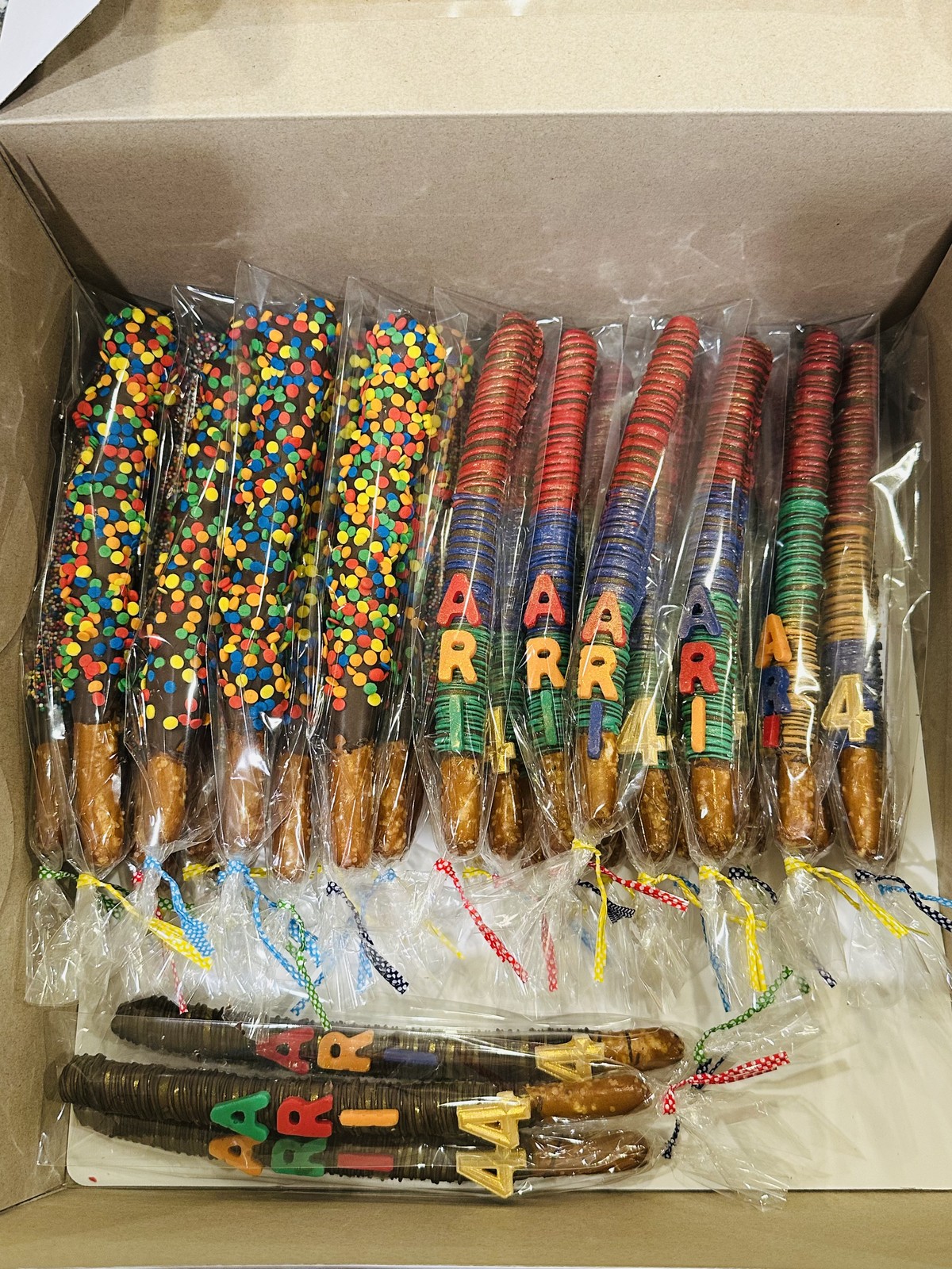 Mixed colorful chocolate covered pretzel assortment with sprinkles and alphabet decorations