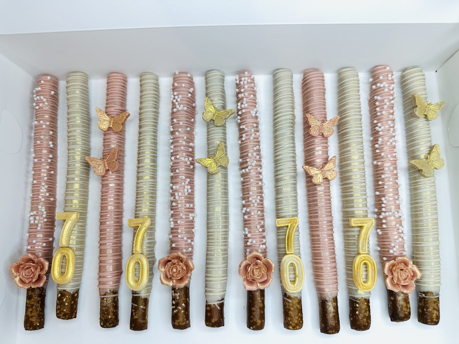 Pink chocolate covered pretzel rods with matching sprinkles