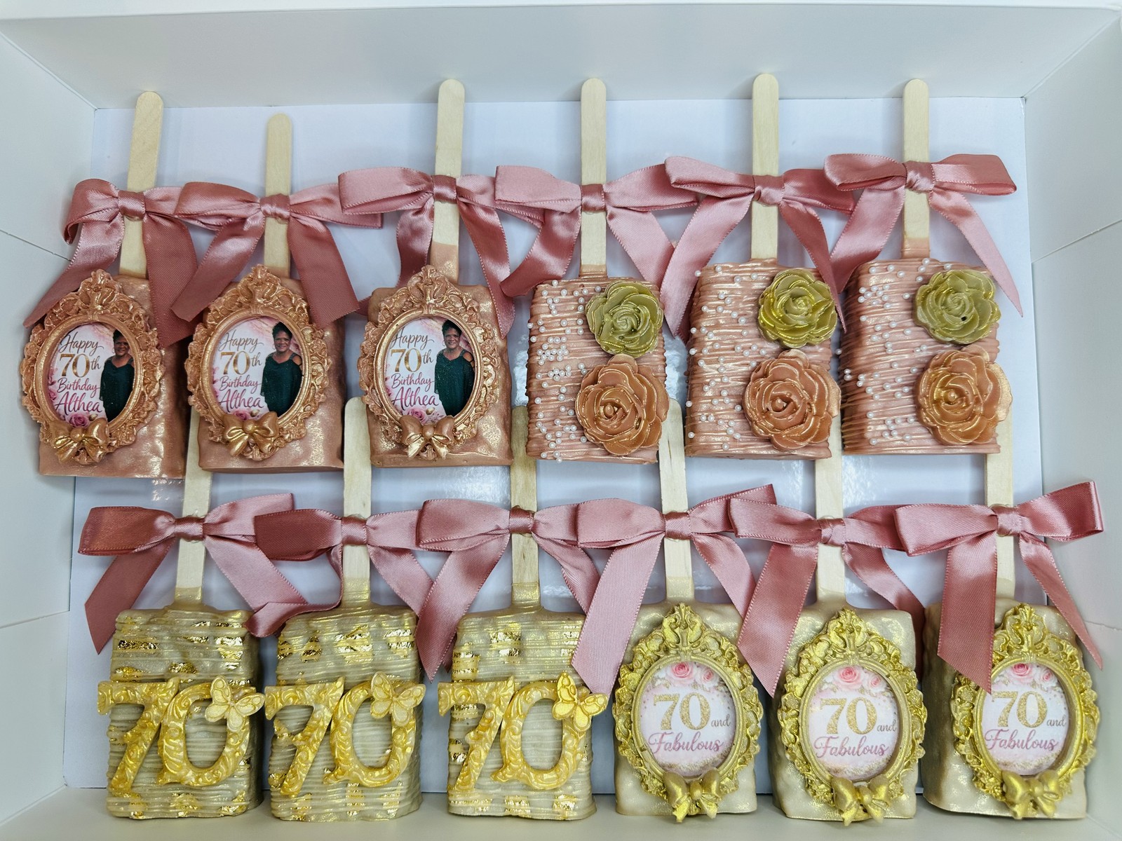 Elegant blush, ivory, and gold 70th birthday chocolate covered Rice Krispie treat collection with framed portraits and floral details