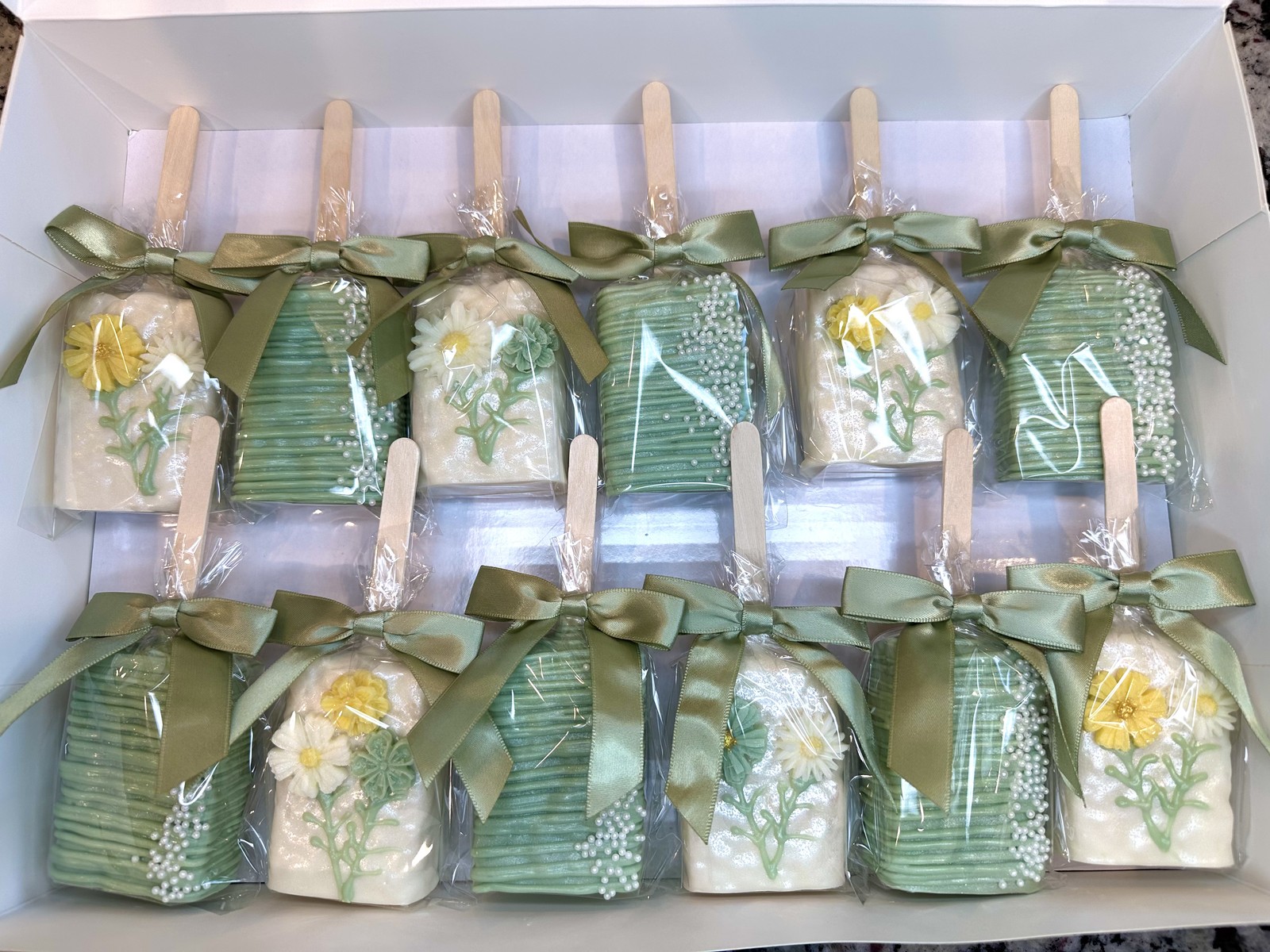 Sage green and ivory floral chocolate covered Rice Krispie treat collection with daisies, pearls, and coordinated satin bows
