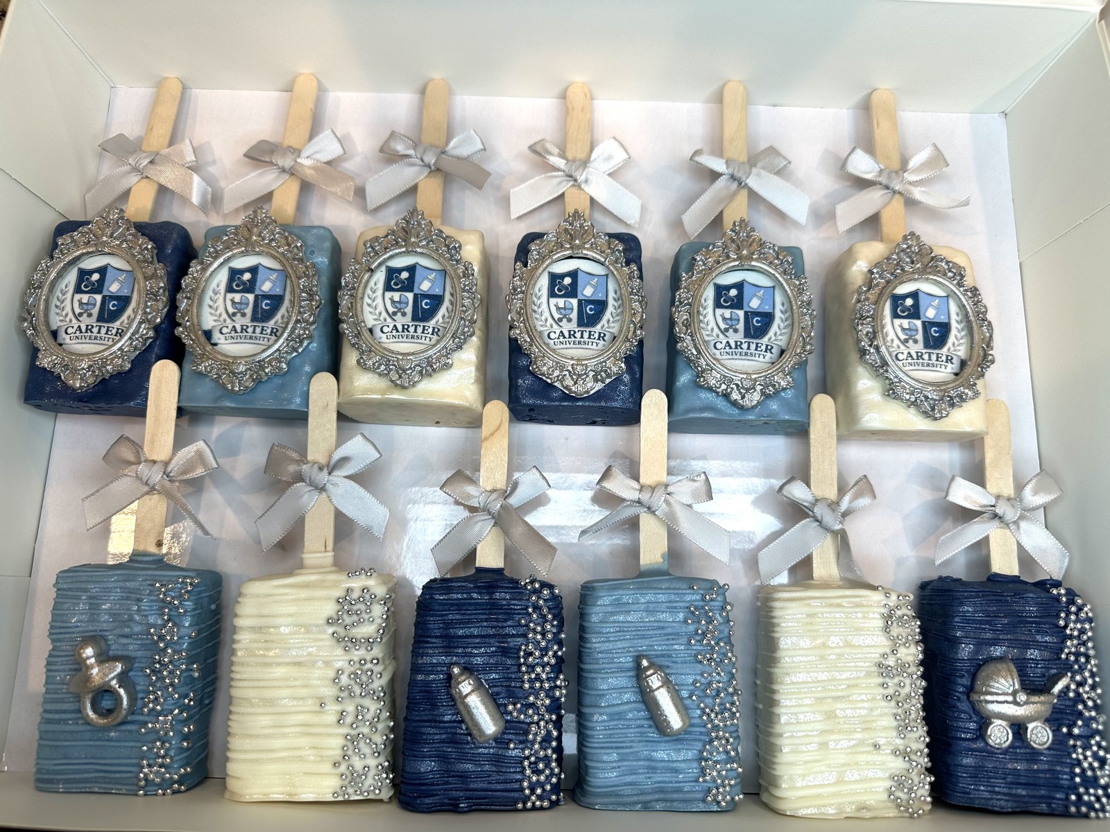 Elegant navy blue, powder blue, ivory, and silver Carter University baby shower chocolate covered Rice Krispie treat collection with ornate framed crests and baby details