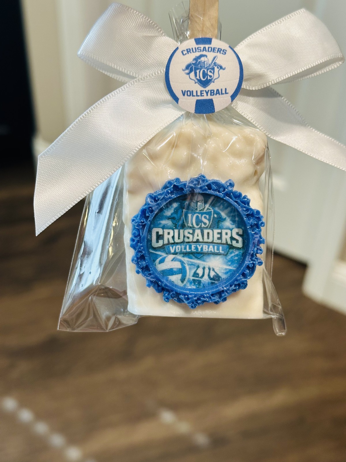 Individually wrapped blue framed Crusaders volleyball chocolate covered Rice Krispie treat with white bow