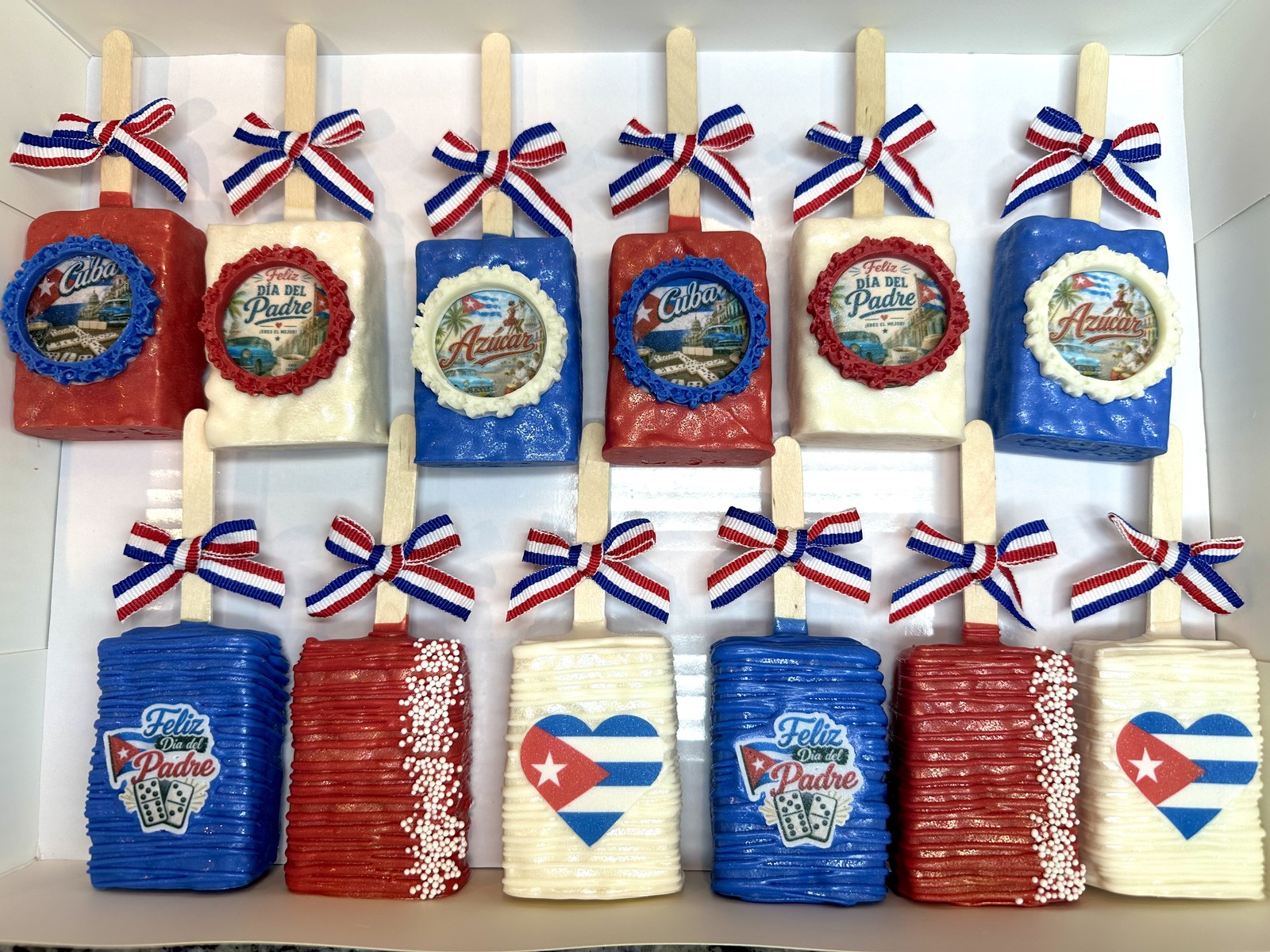 Red, white, and blue Cuban themed chocolate covered Rice Krispie treat collection with Father’s Day designs, ornate edible frames, and ribbon bows
