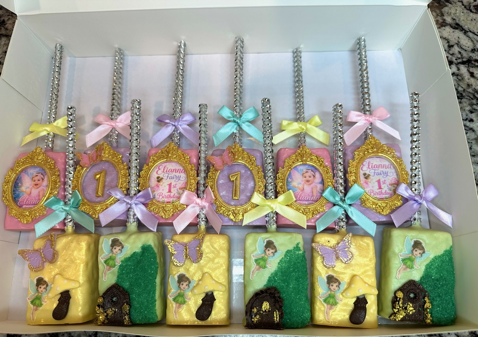 Luxury pastel fairy first birthday chocolate covered Rice Krispie treat collection with gold ornate frames, rhinestone sticks, satin bows, butterflies, and fairy garden details