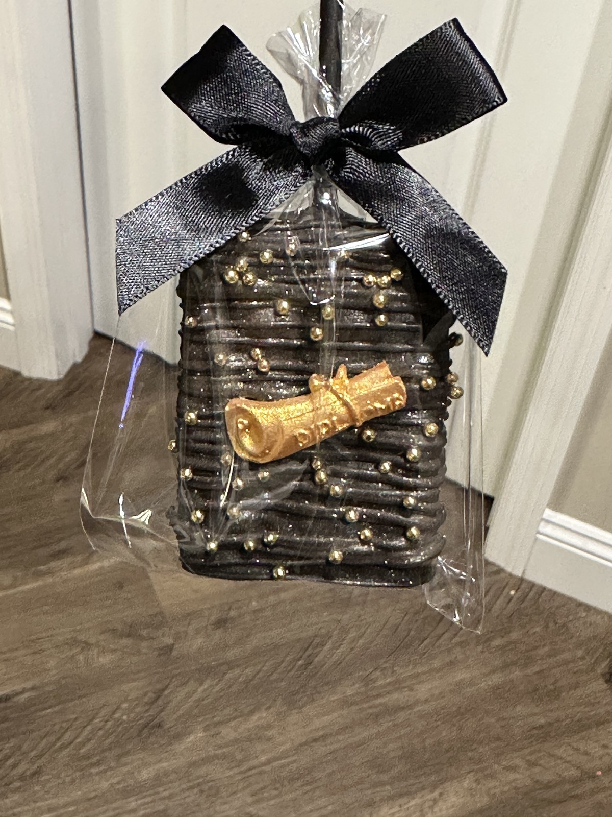 Individually wrapped black and gold graduation chocolate covered Rice Krispie treat with 2026 design and black bow