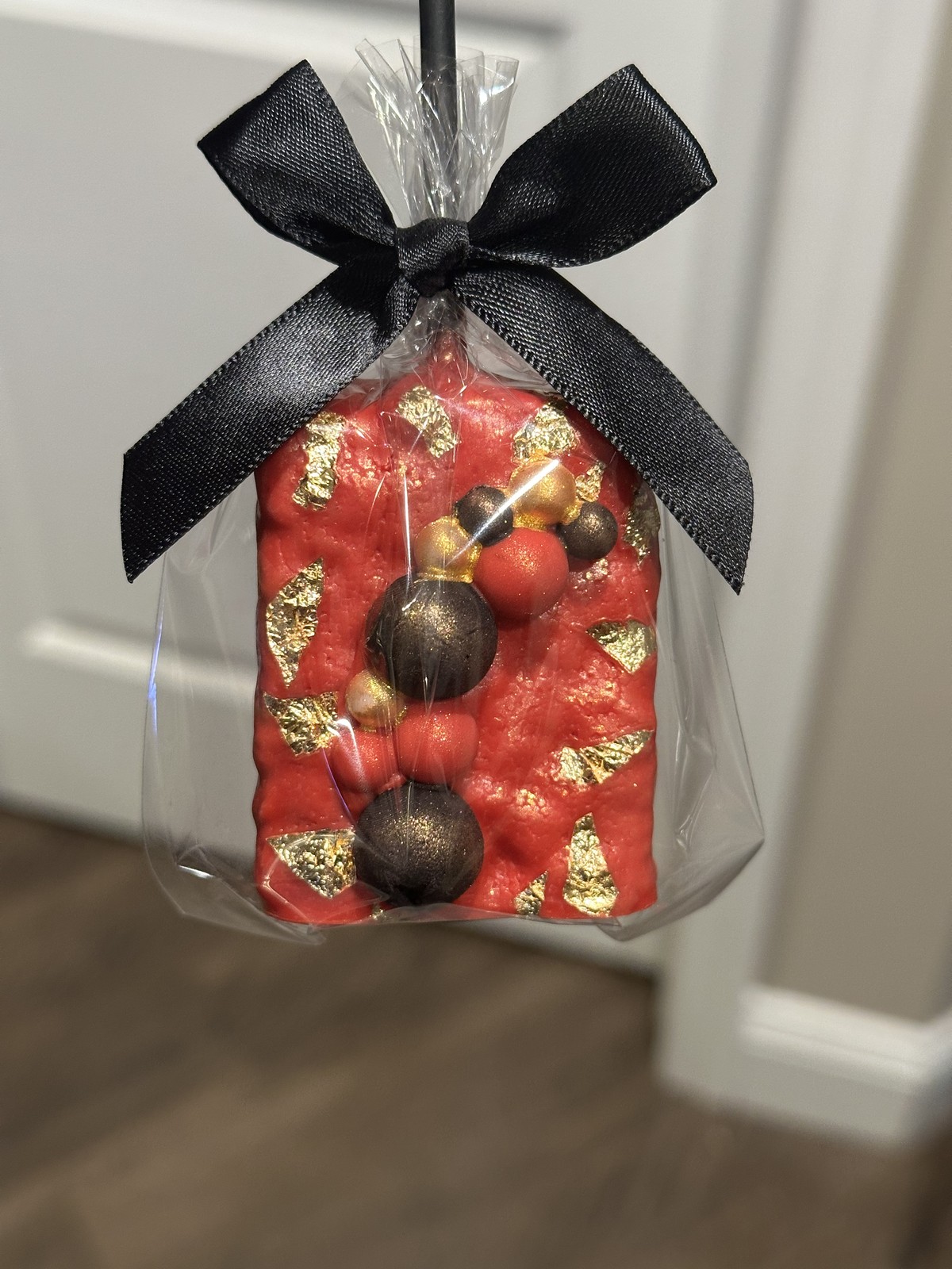 Individually wrapped black and gold graduation chocolate covered Rice Krispie treat with diploma detail and black bow