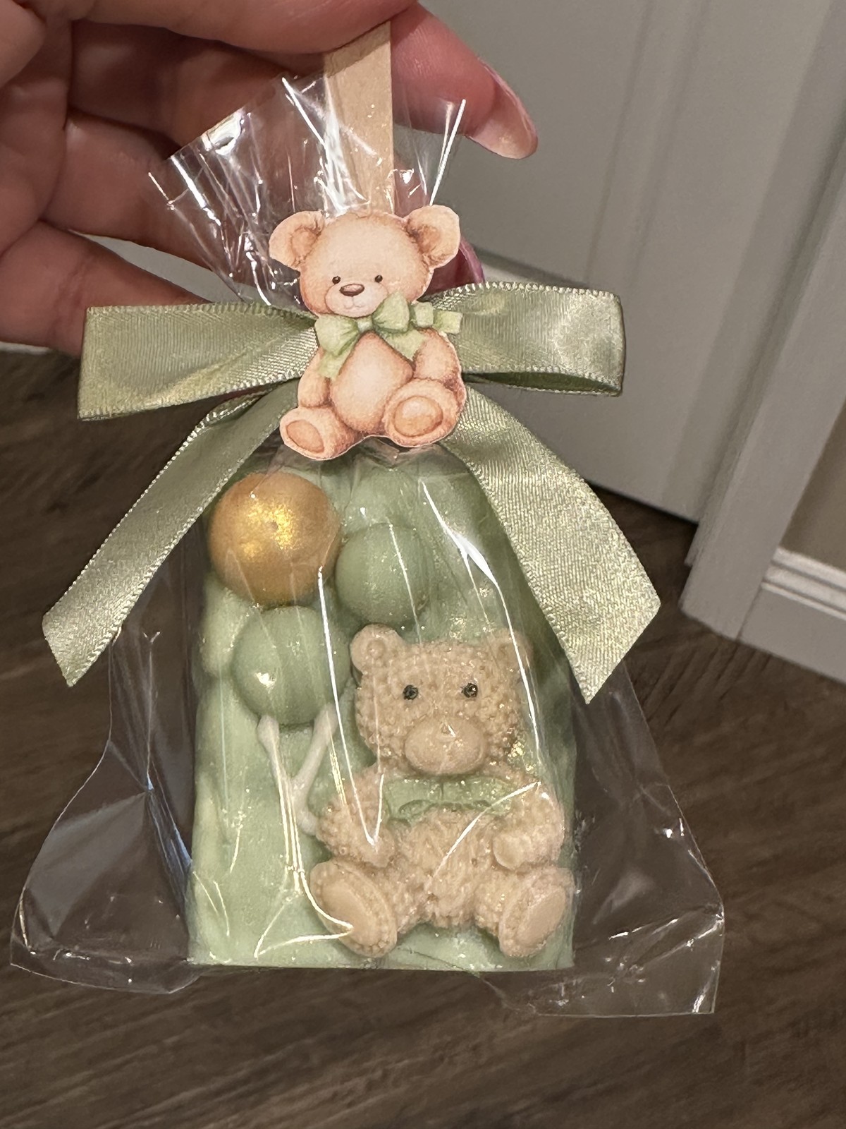 Individually wrapped sage green teddy bear chocolate covered Rice Krispie treat with decorative chocolate bubbles and bow